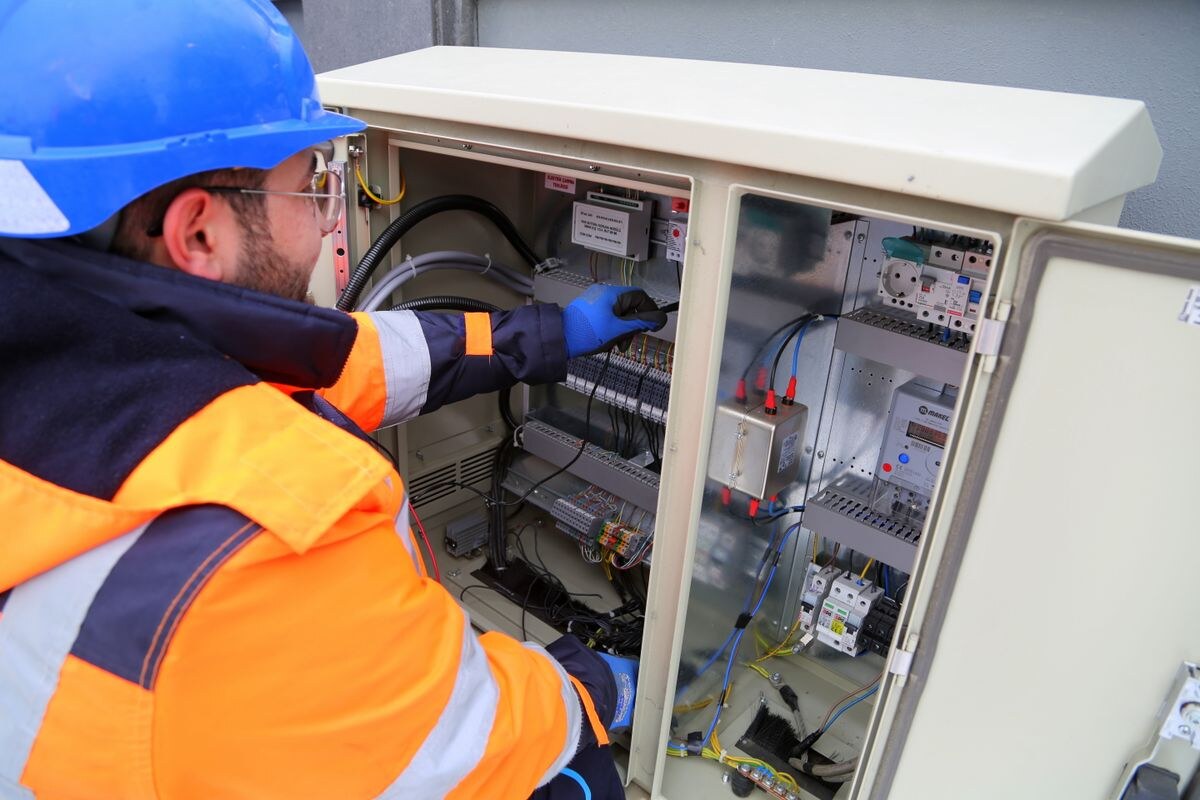 Monteur sluit een installatie aan in een elektrische verdeelkast