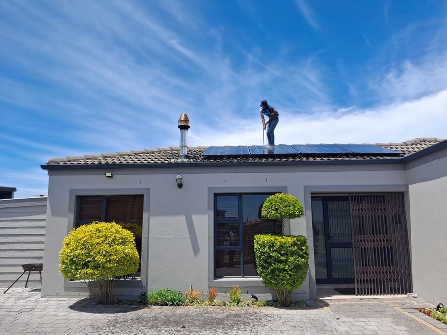 Monteur legt zonnepanelen op het dak van een woning